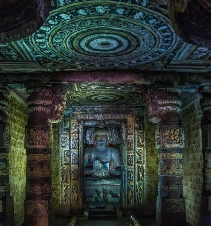 Carved Buddhist sculpture in the dark interior of an Ajanta cave